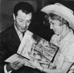 Taylor receives a gift of Nebraskaland Stamps from Jan Schenck of the Information and Tourism Division of the Nebraska Division of the Nebraska Game and Parks Commission on October 25, 1963. (Omaha World Herald)